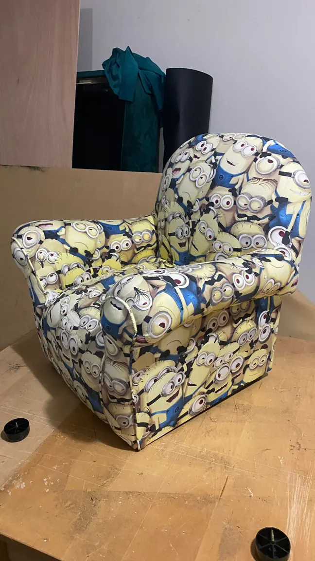 A child-sized armchair recovered in a bright cartoon print.